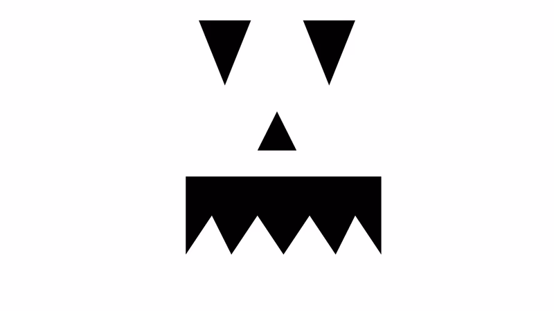 Five classic pumpkin carving stencil designs laid out on a table