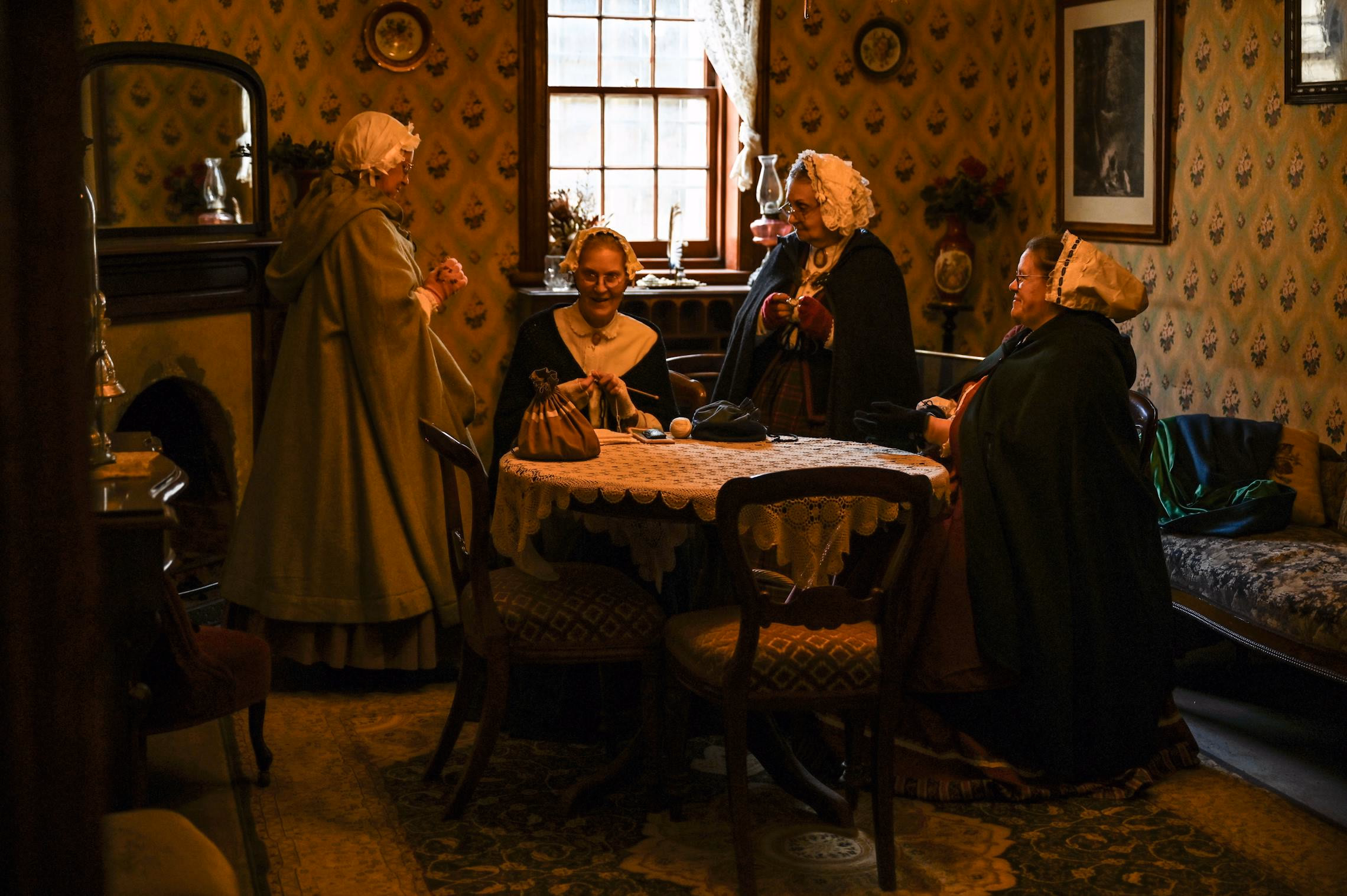 Candlelit Victorian parlor with draped table suggesting a seance setting