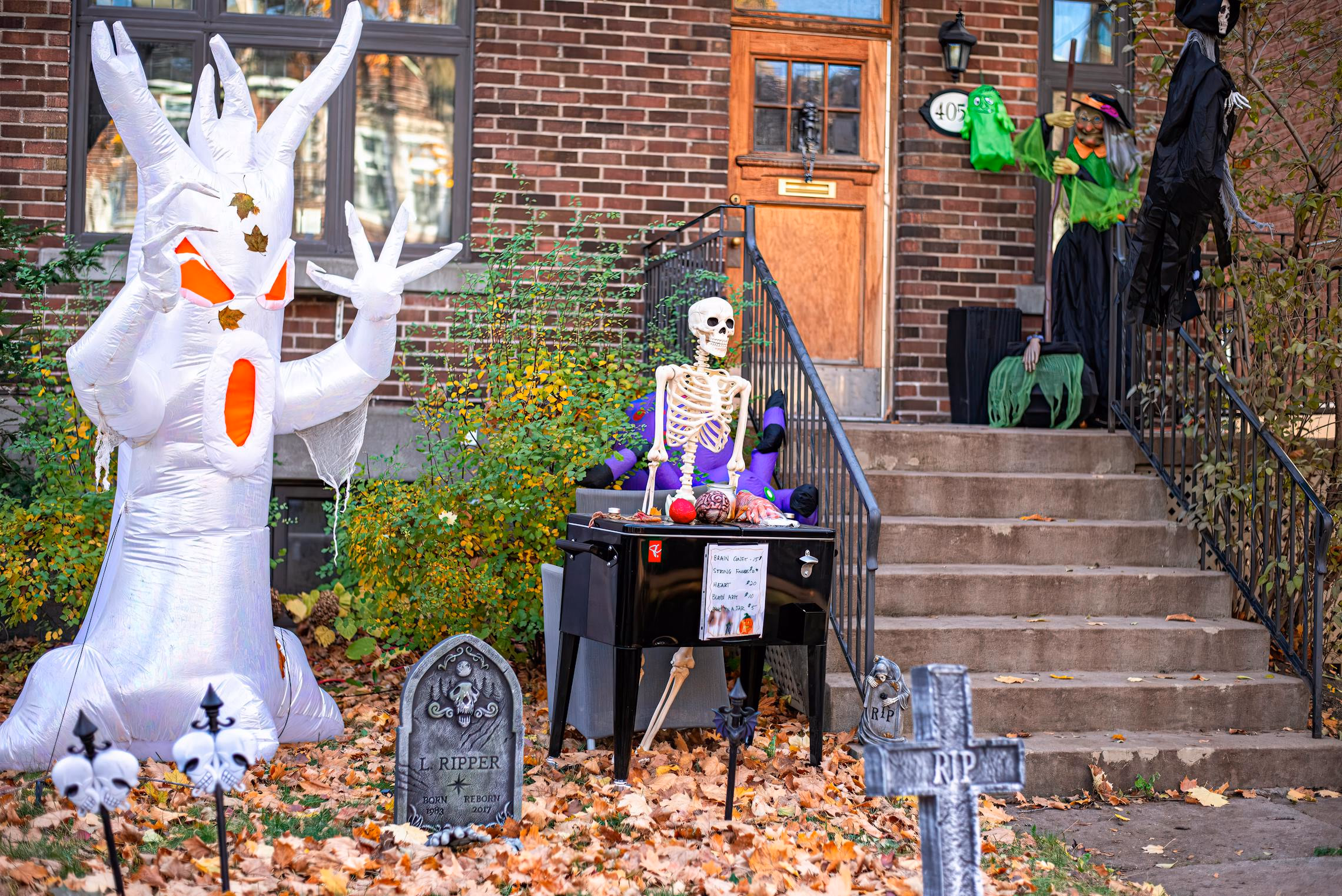 Giant inflatable Halloween decoration lit up in a front yard at dusk